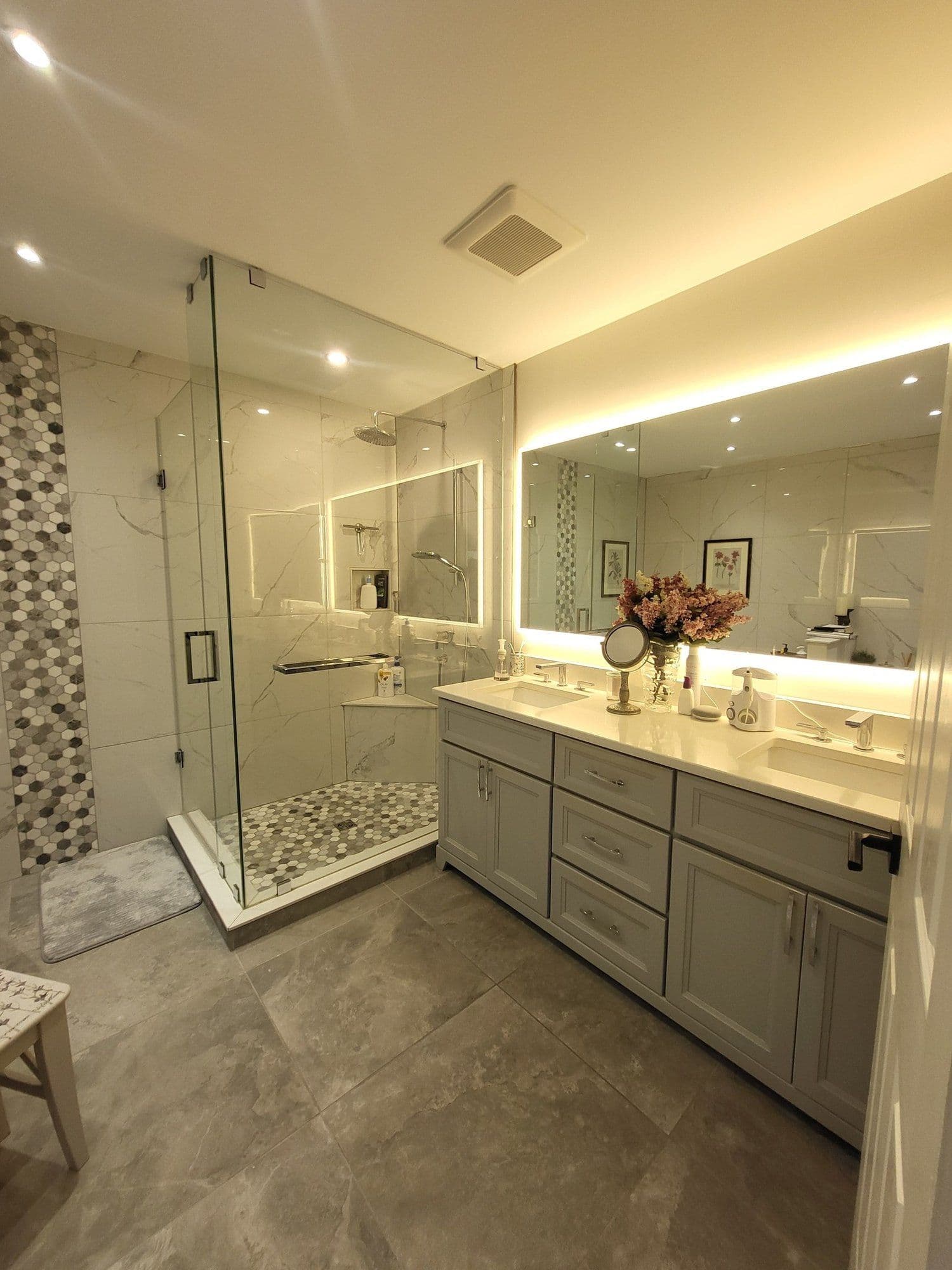 Marble master bathroom with glass shower and dual vanity, professionally cleaned by Luxury Estate Cleaners